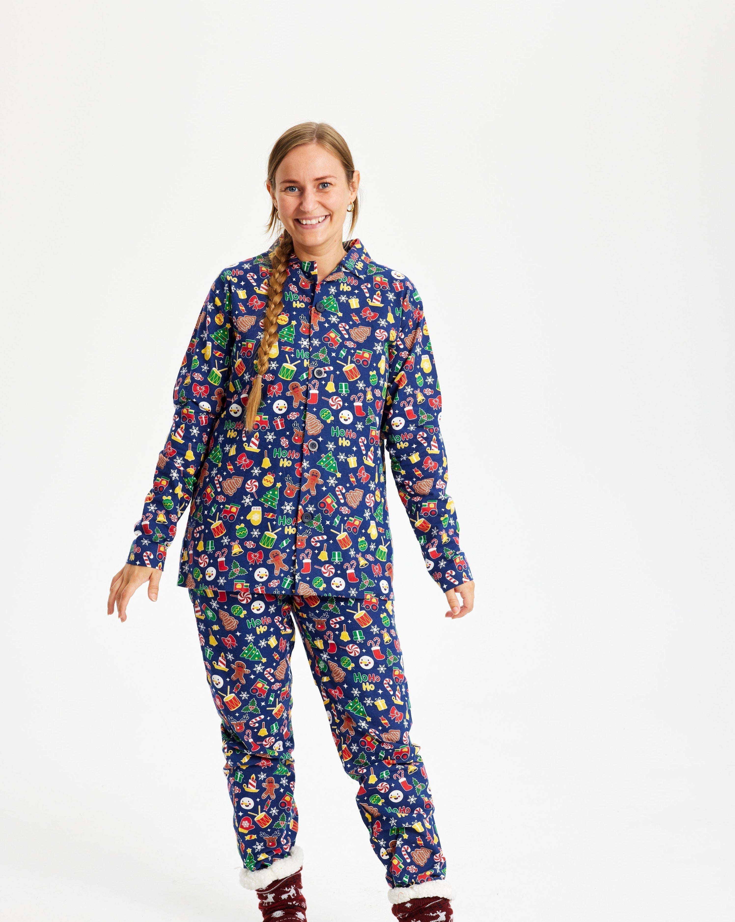 Une femme portant un pyjama de Noël bleu avec un imprimé de Noël.